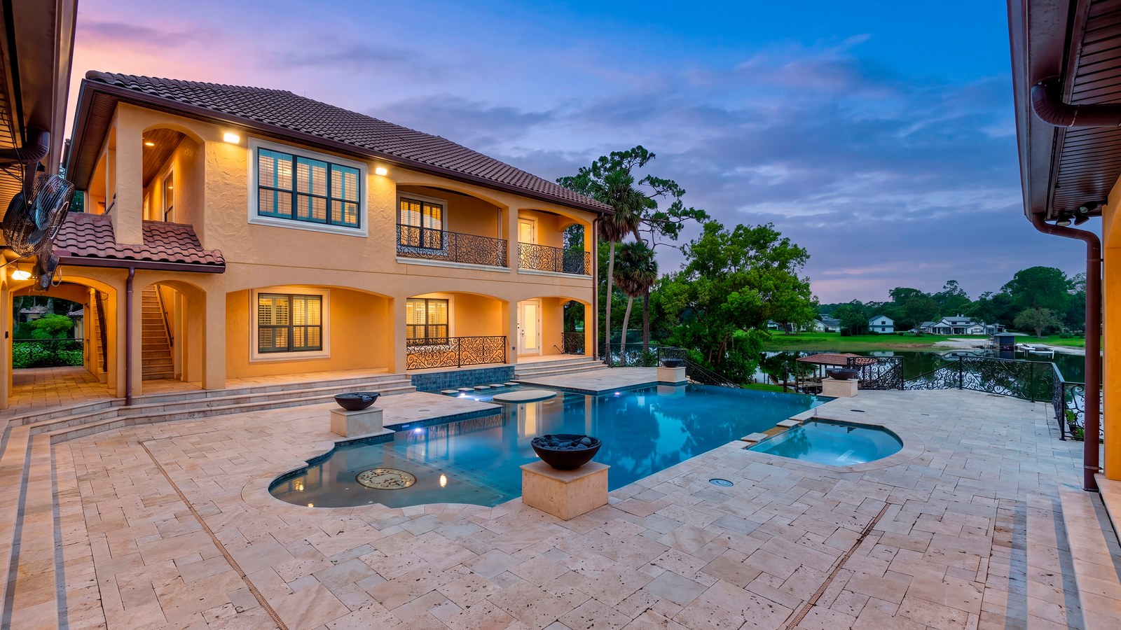 Twilight view of the estate's pool, spa, and rear terrace